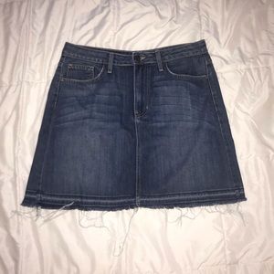 Dark wash denim skirt with raw hem and pockets